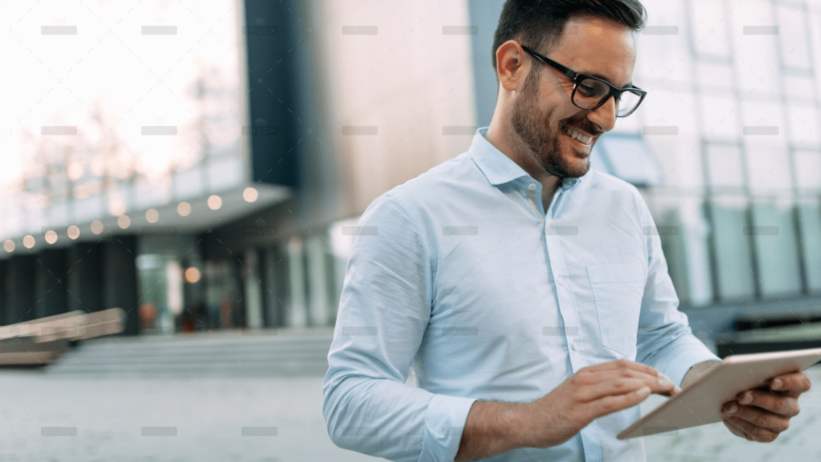 demo-attachment-59-portrait-of-businessman-in-glasses-holding-tablet-AWVHCJU